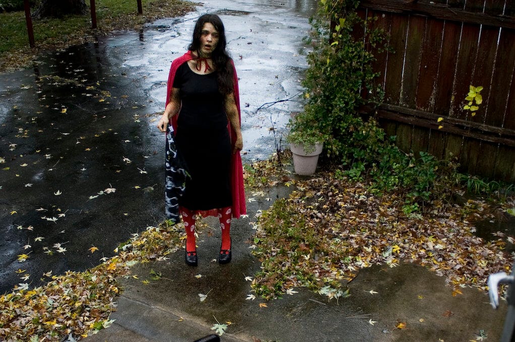 photo of female zombie standing at bottom of front porch stairs