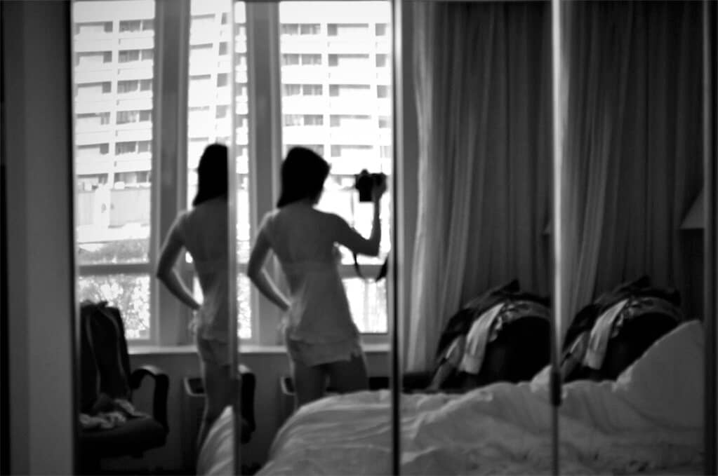 woman in bedroom holding camera