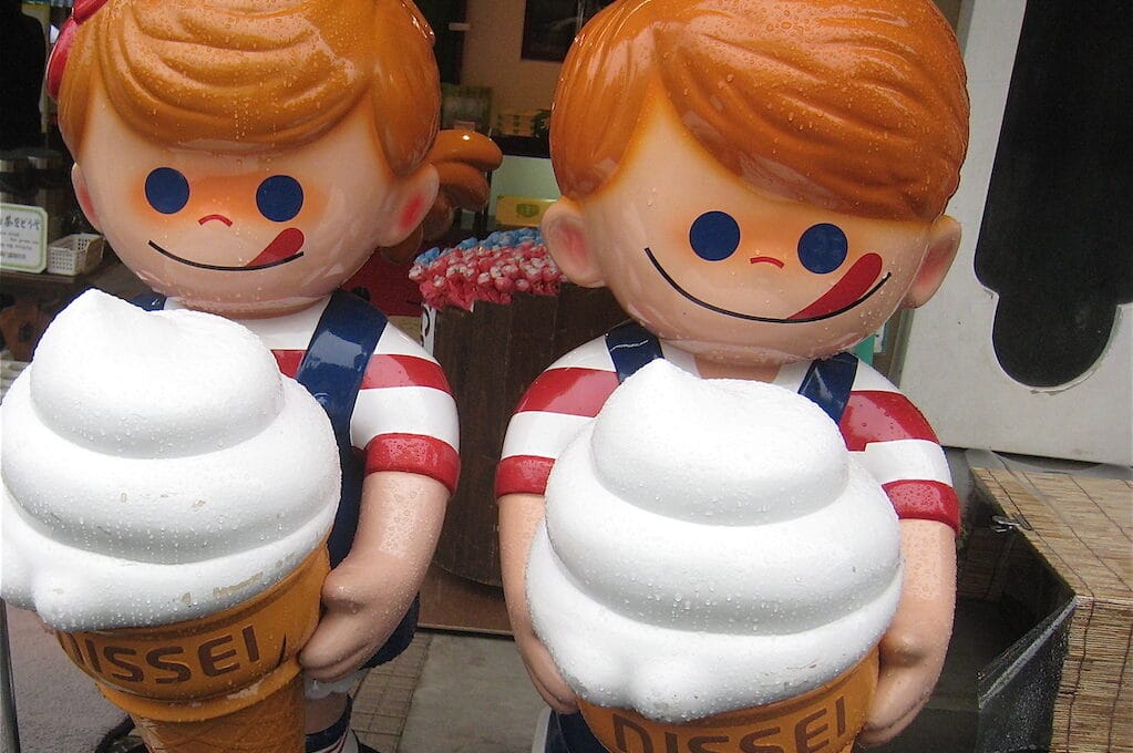photo of two statues holding ice cream cones