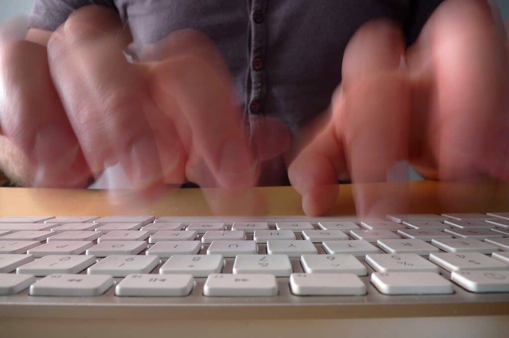 photo of hands typing on computer keyboard