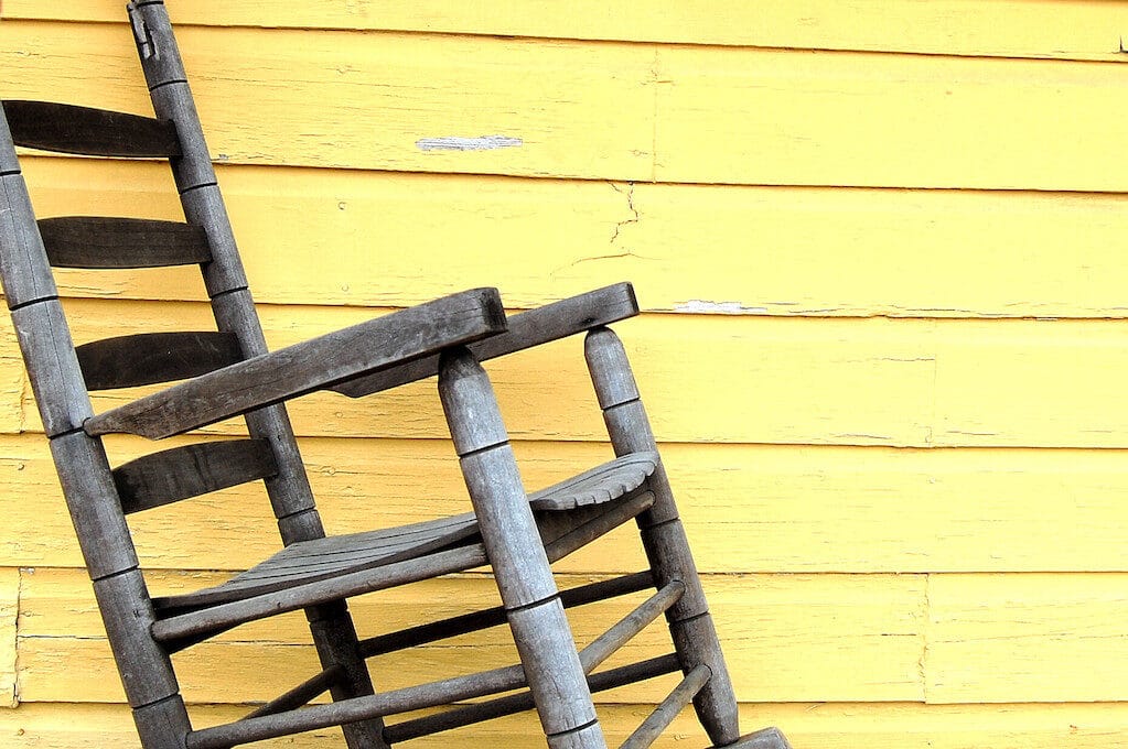 photo of wooden chair in front of yellow wall