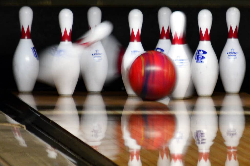 photo of bowling ball striking pins