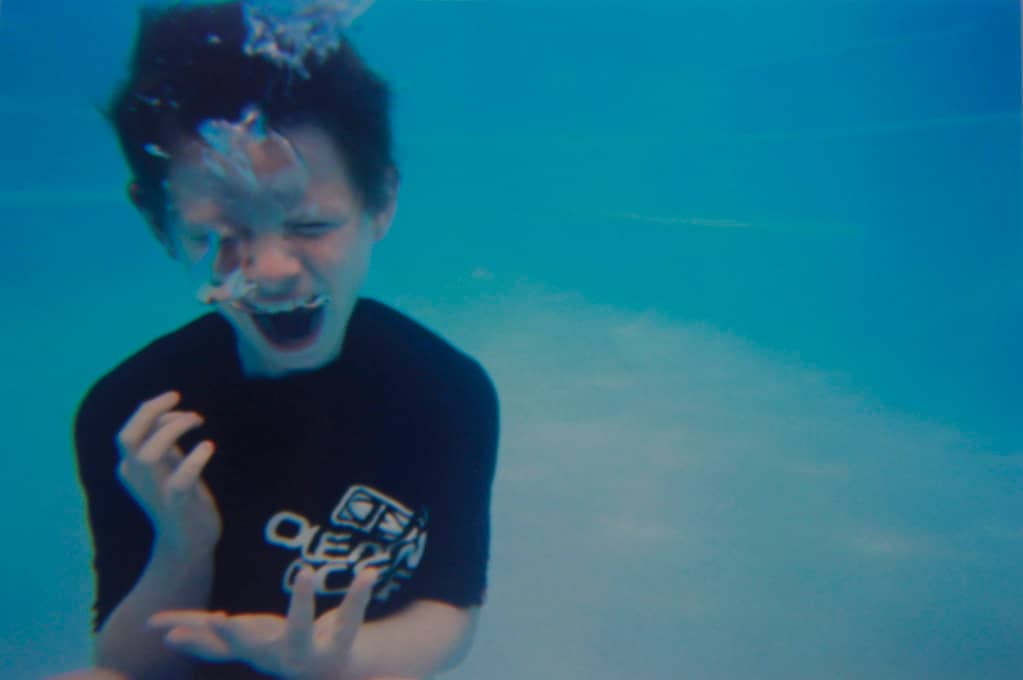 photo of boy screaming underwater