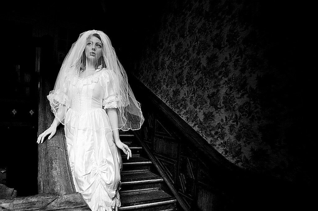 photo of woman in bridal gown posing on old staircase