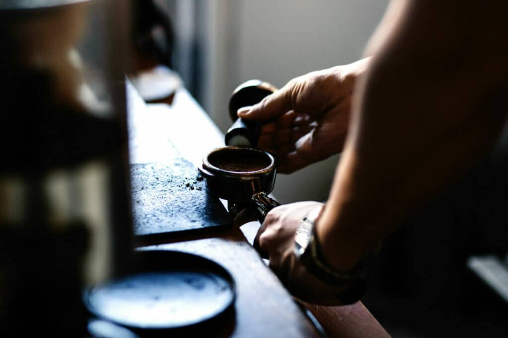 photo of barista tamping espresso
