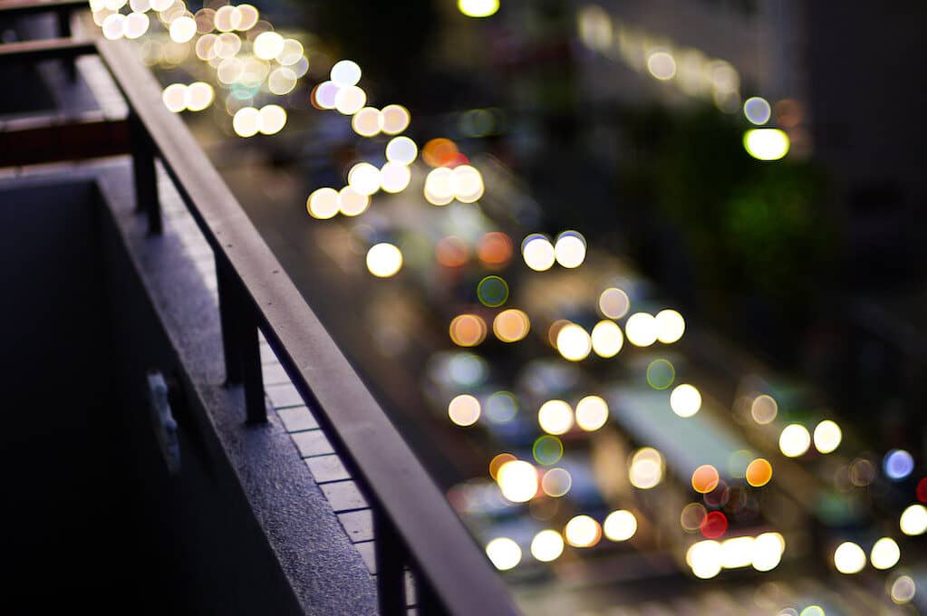 photo of railing overlooking traffic below at night