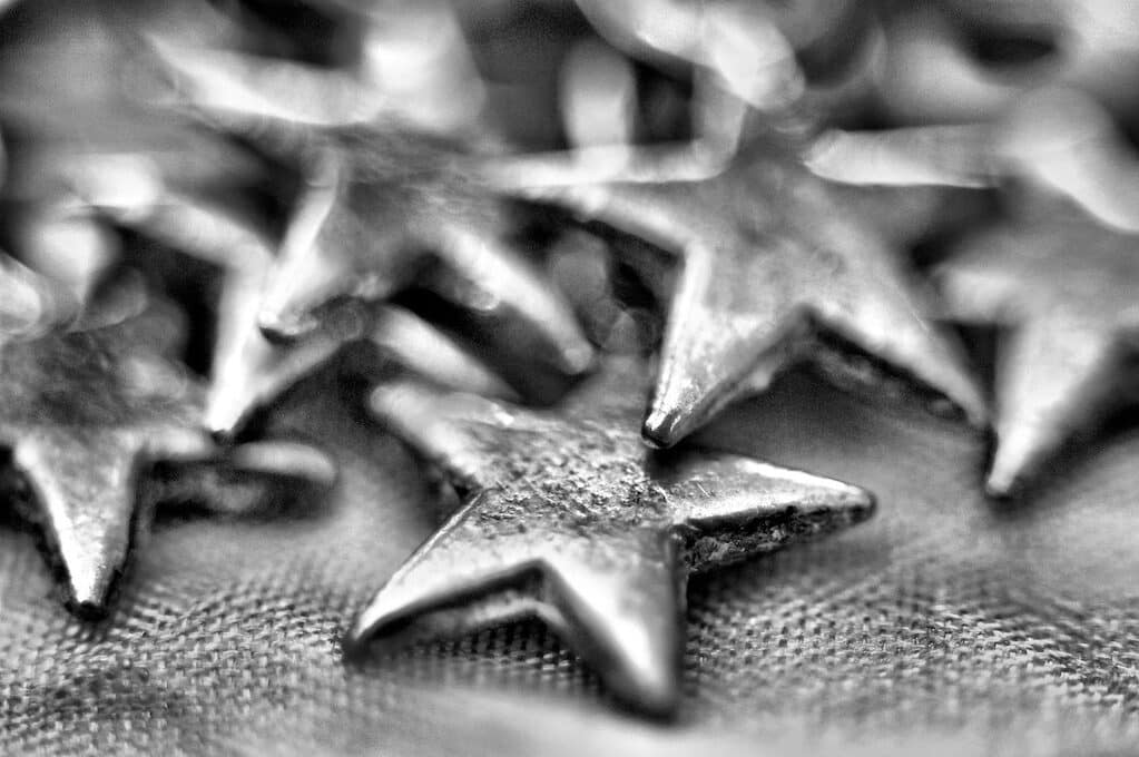 black and white photo of metallic stars on a textured surface