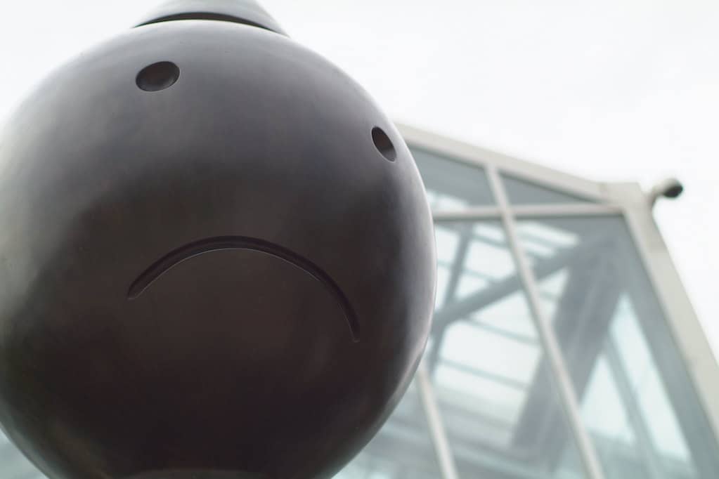 photo of frowny face on statue