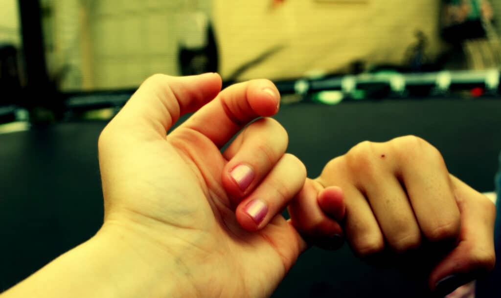 photo of two hands forming a pinky promise