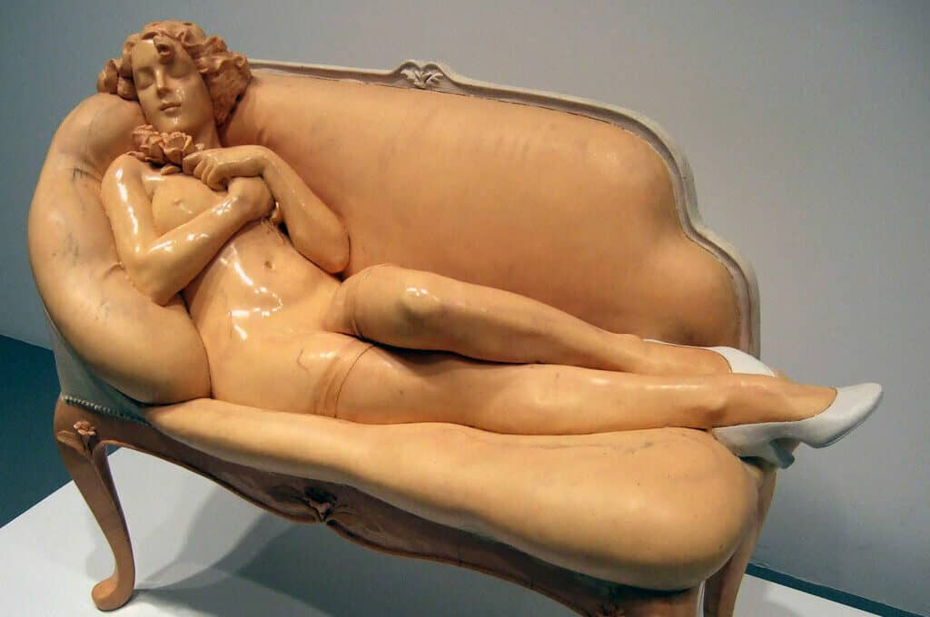 sculpture of nude woman reclining on couch