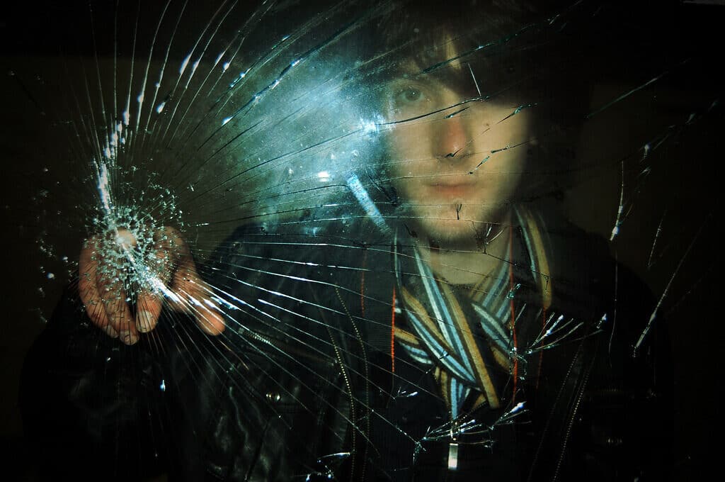 photo of man touching broken glass
