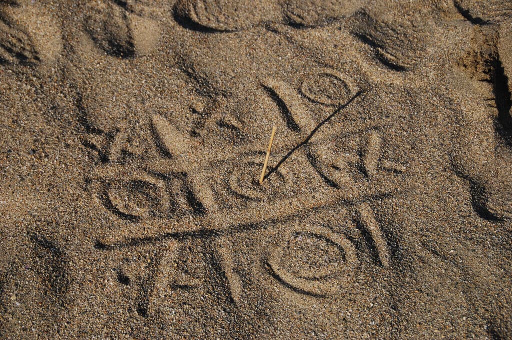 photo of tic-tac-toe game drawn into sand
