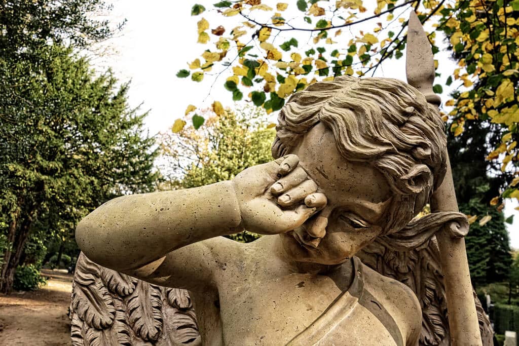photo of angel statue rubbing its eye