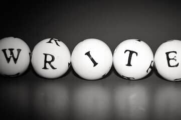 Black & white image of letters on 5 small balls that spell out the word "writer"