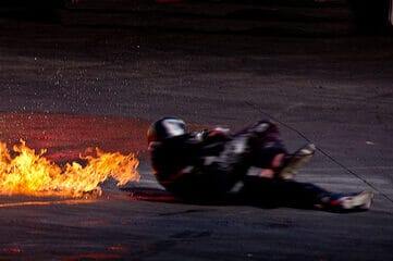 photo of a stuntman on ground near fire